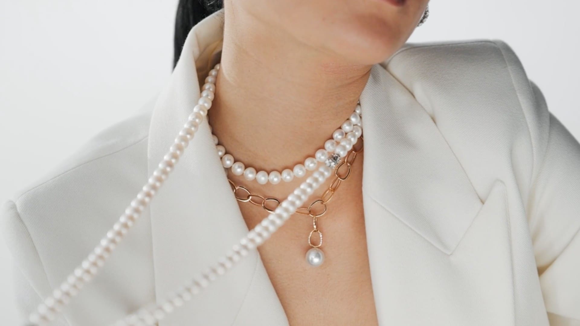 Perlenschmuck online kaufen: Frau in weiß trägt Perlenkette